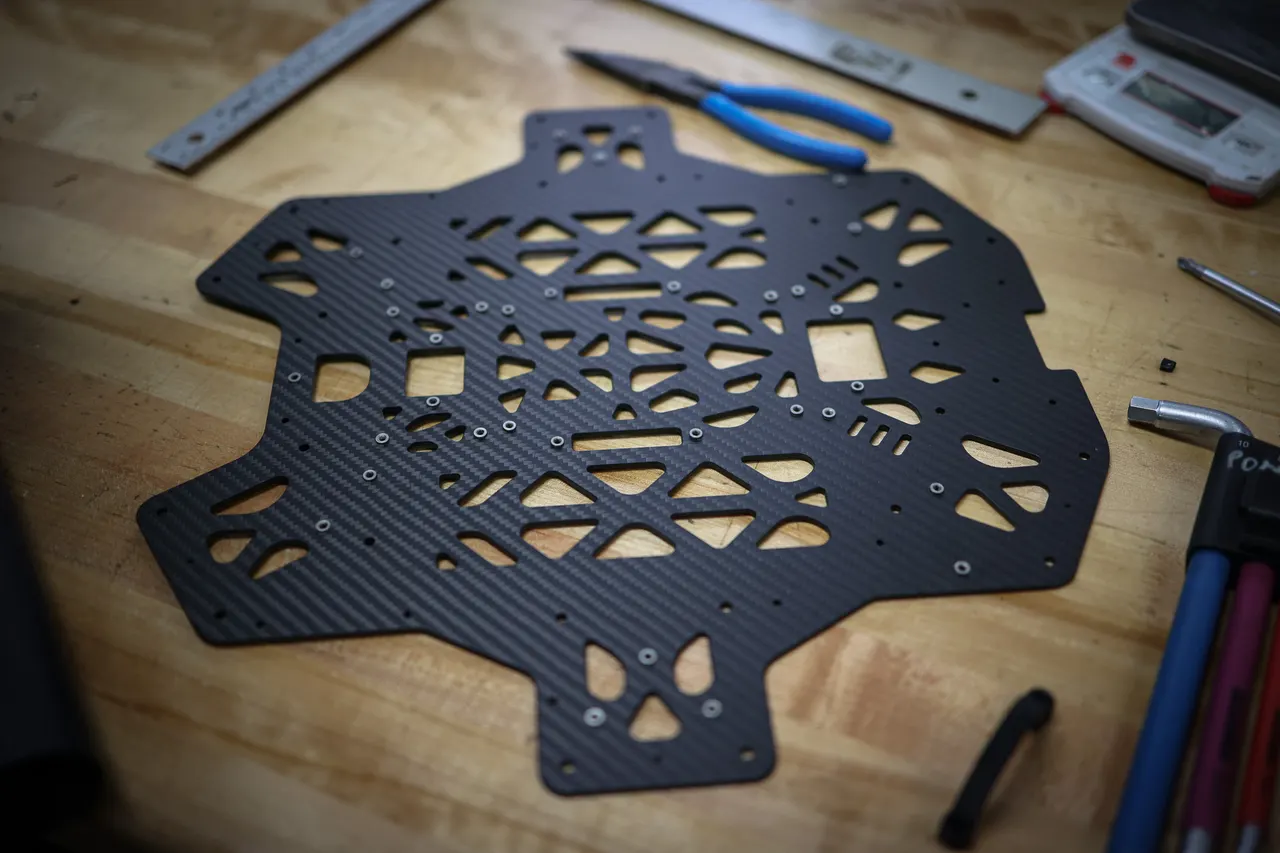 Composant de châssis en fibre de carbone sur un banc d'atelier, entouré d'outils